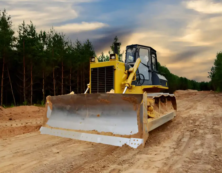 Industrial bulldozer on demolition site with forest backdrop, ready for land clearing and site preparation