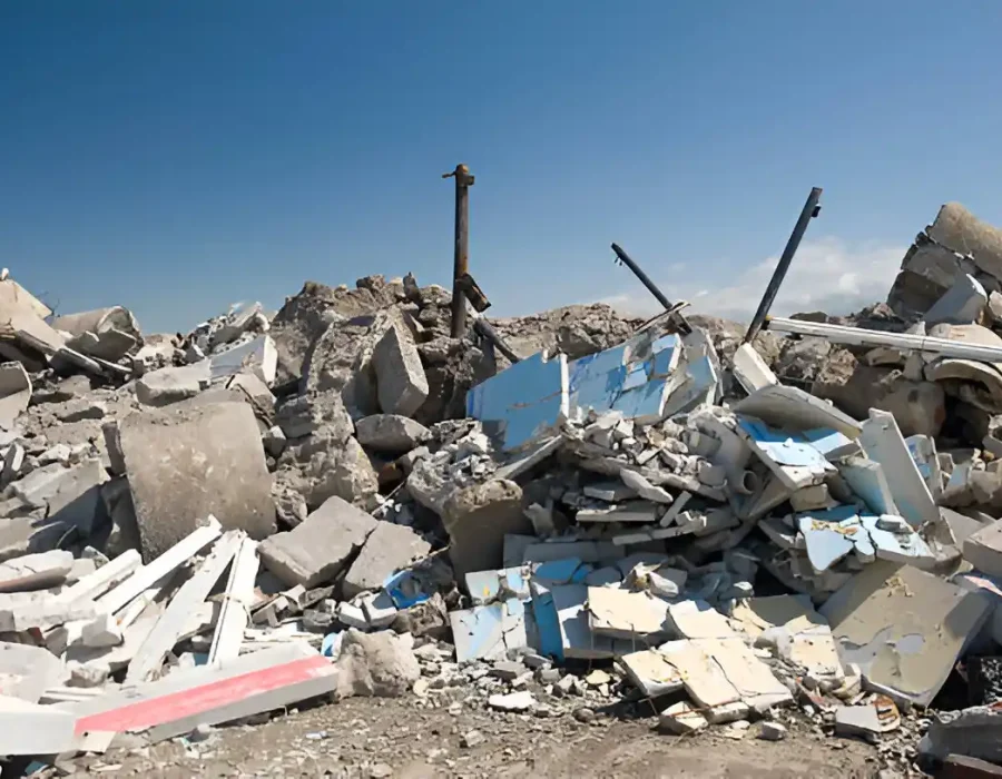 Large pile of mixed demolition debris with concrete blocks and building materials awaiting removal