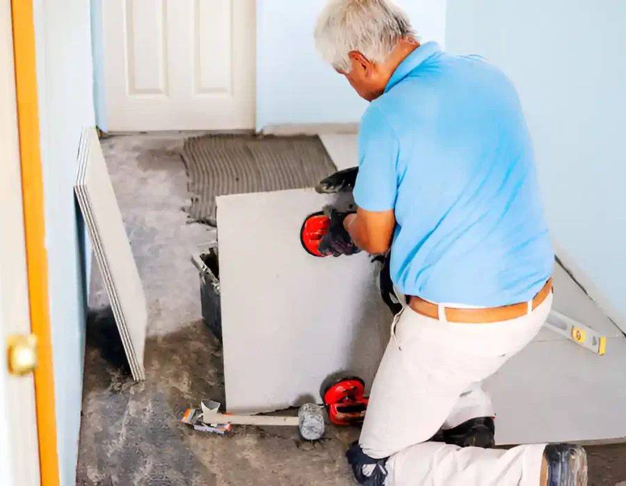Man handling drywall with suction tools during room renovation or demolition preparation.