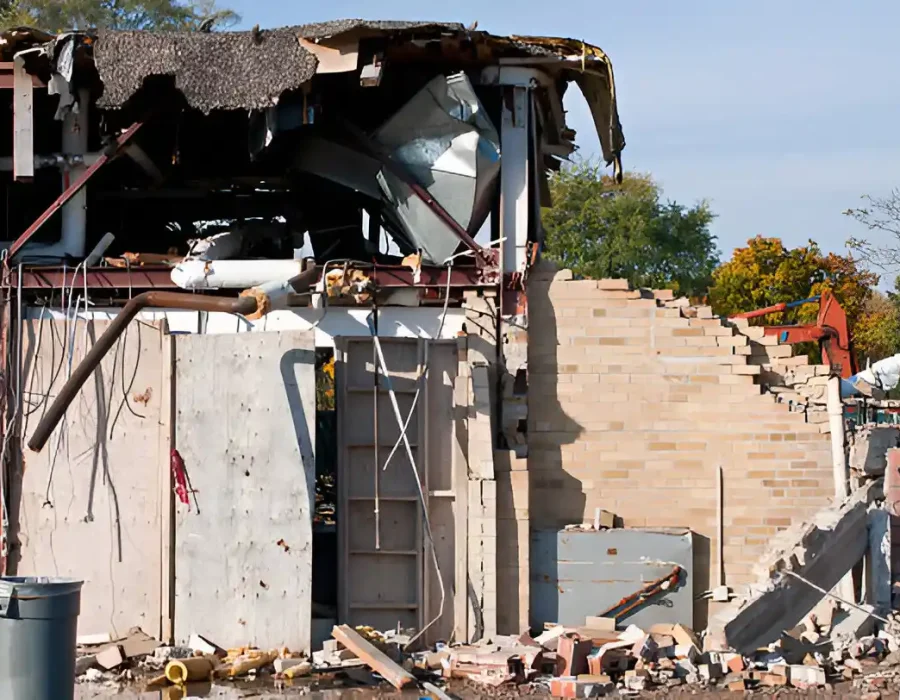 Partially demolished building with exposed framework, concrete, and brick rubble