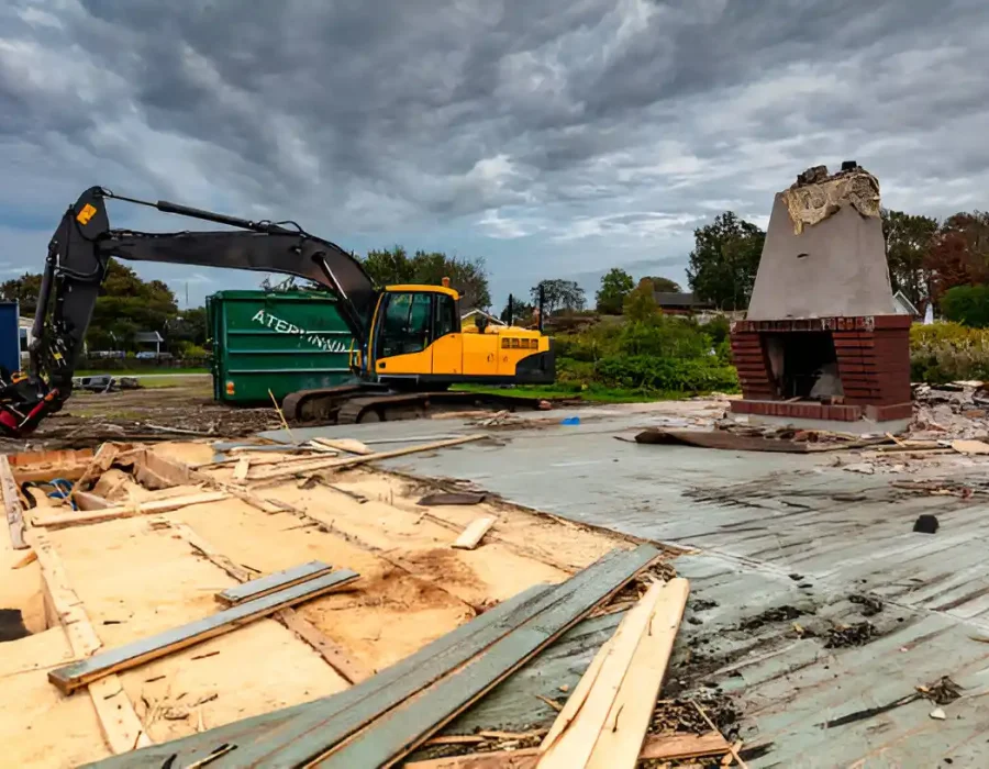 Larcher excavator dismantling multi-story house with yellow crane, professional demolition