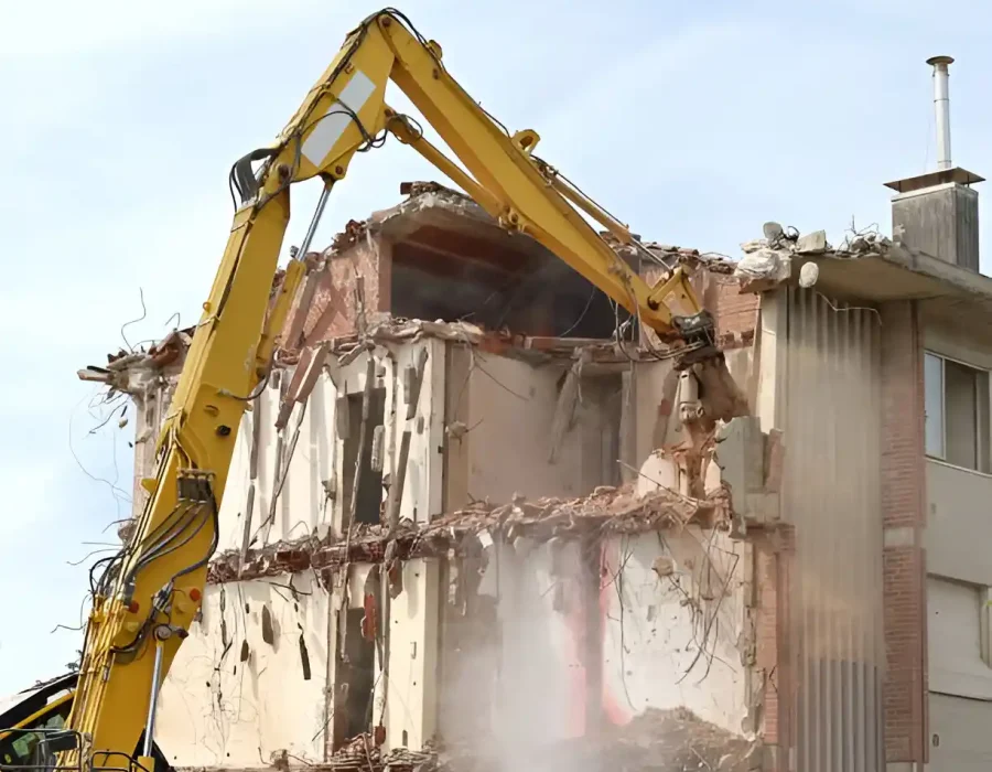 Yellow demolition excavator dismantling brick structure, professional urban site clearance