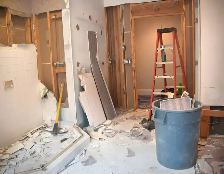 Construction site with debris, ladder, and waste bin during home renovation