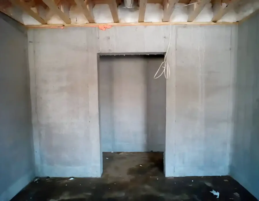 Interior space with concrete walls and exposed ceiling, ready for demolition or renovation work.