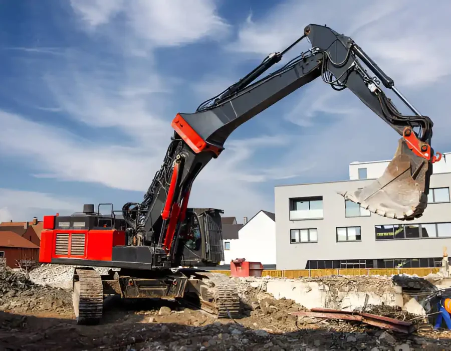 Red and black excavator performing residential site preparation and foundation removal services