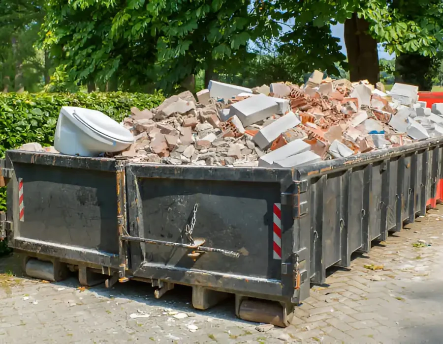 Construction waste dumpsters loaded with brick and concrete rubble from demolition project