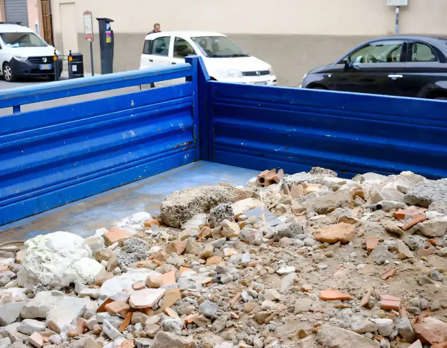Blue roll-off container filled with brick and concrete rubble from urban demolition project