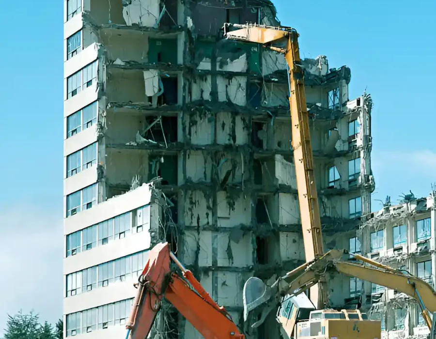 Multiple excavators dismantling multi-story office building with systematic deconstruction