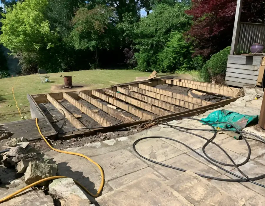 Partially demolished wooden deck during removal and site cleanup.