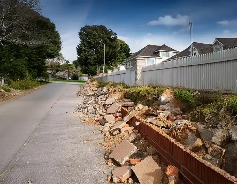Heavy equipment demolishing a building and removing debris, showcasing efficient demolition and cleanup services.