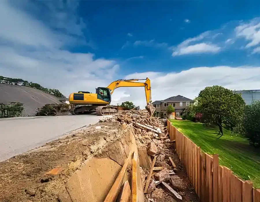 Heavy machinery dismantling a structure and clearing debris, highlighting professional demolition and site cleanup.
