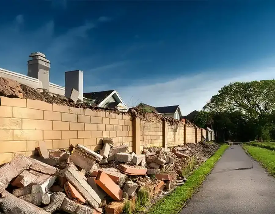 Heavy machinery demolishing a structure and clearing debris, highlighting professional demolition and cleanup solutions.
