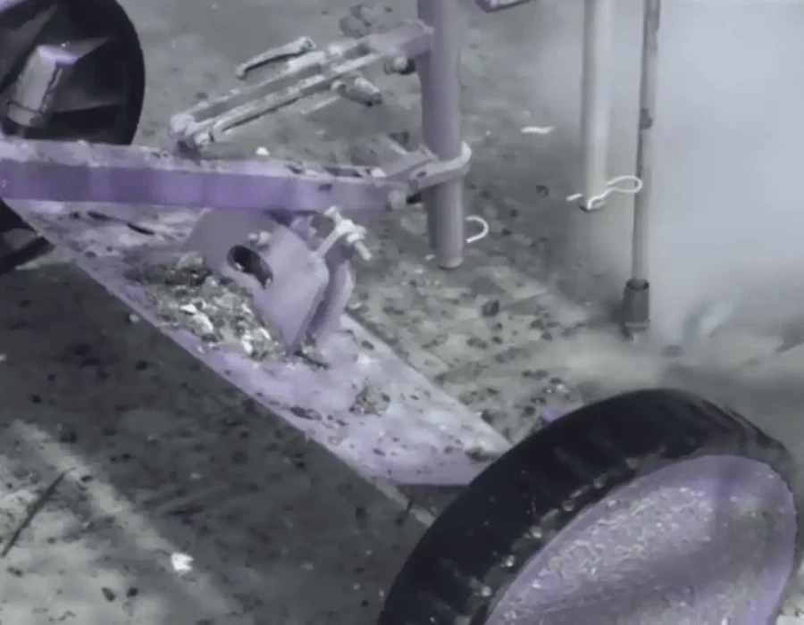 Industrial floor scraper removing surface material with integrated debris collection system