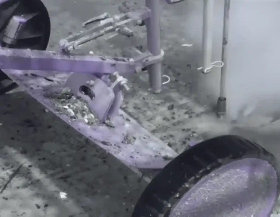 Close-up of robotic demolition tool with dust and debris during concrete grinding process