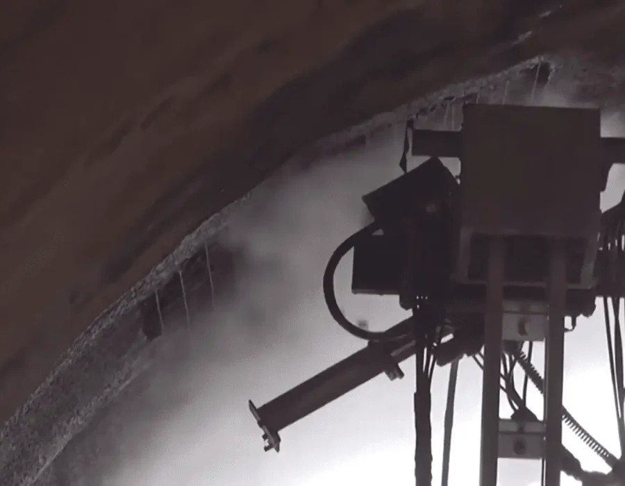 Robotic demolition arm performing controlled concrete removal in underground tunnel setting