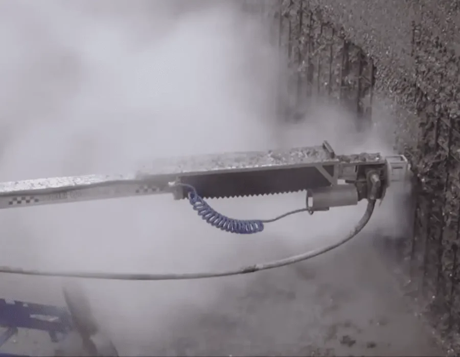 Industrial water jetting equipment performing controlled concrete demolition on vertical surface