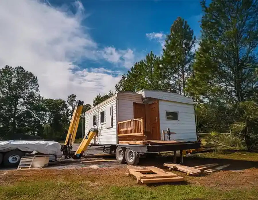 White trailer with stabilizing equipment and construction debris at sunset on excavated work site