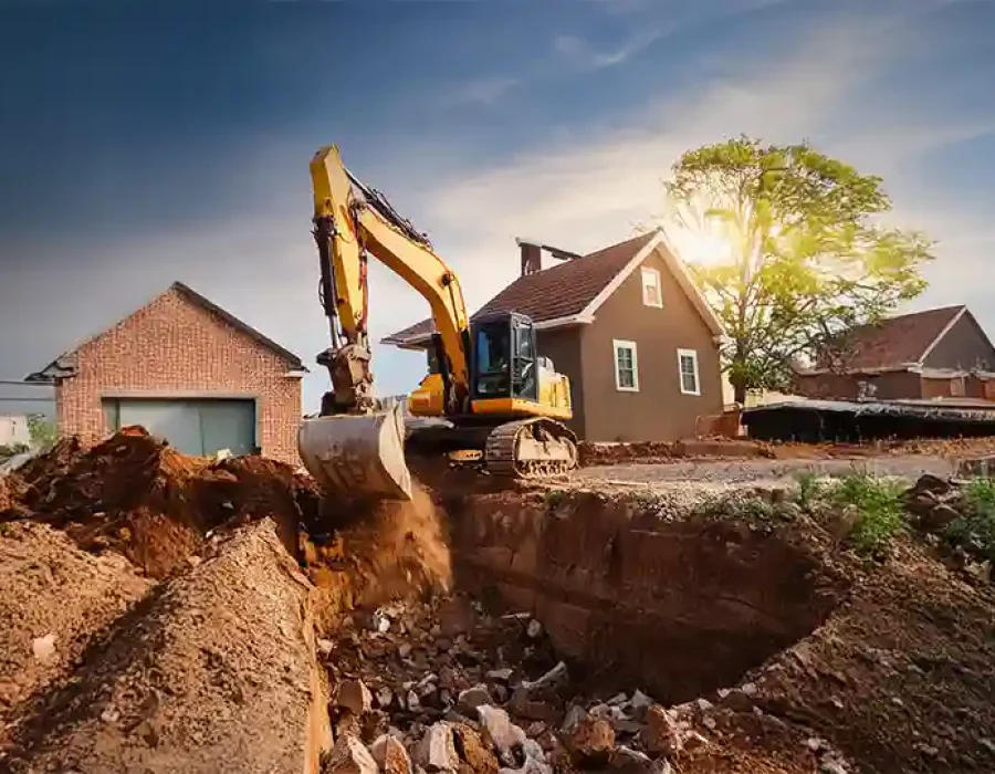 Excavator digging at a house demolition site with debris removal underway.