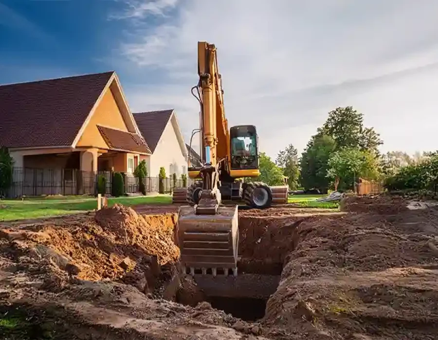 Excavator digging a foundation hole for residential construction site preparation.