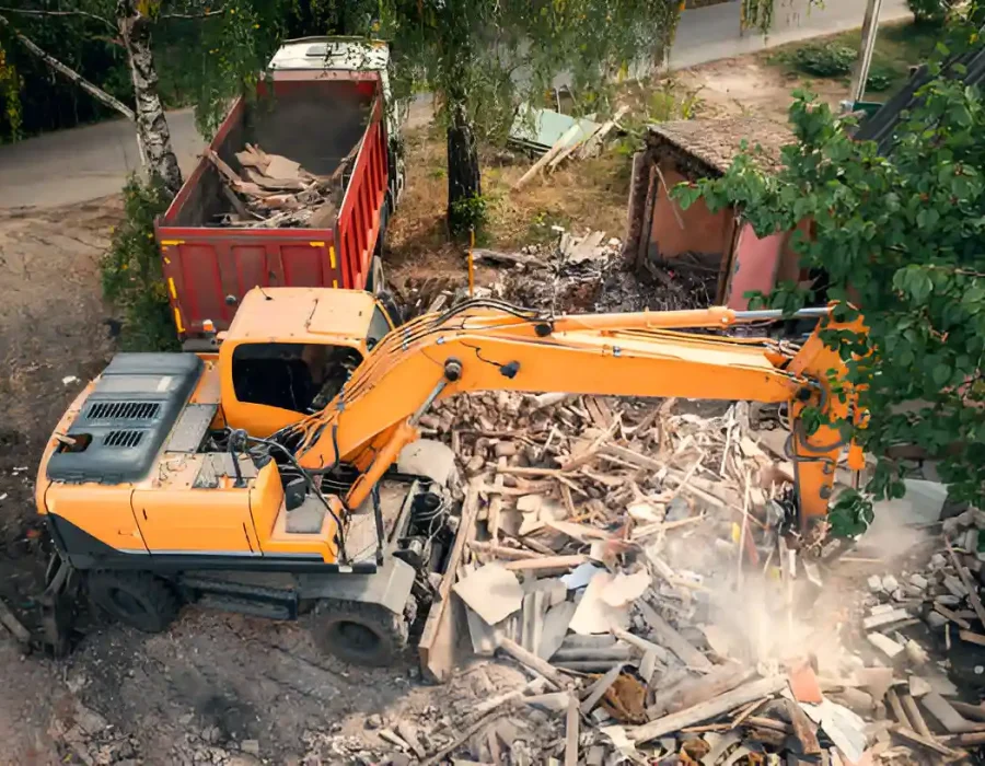 Excavator loading debris into truck for removal services
