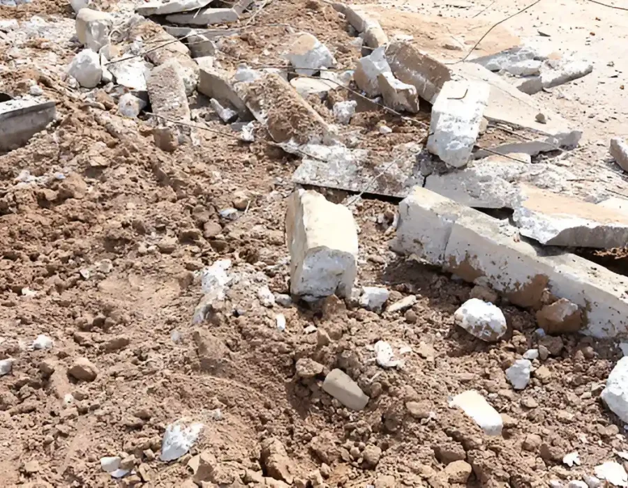 Scattered concrete rubble and construction debris on dirt surface requiring professional demolition cleanup services
