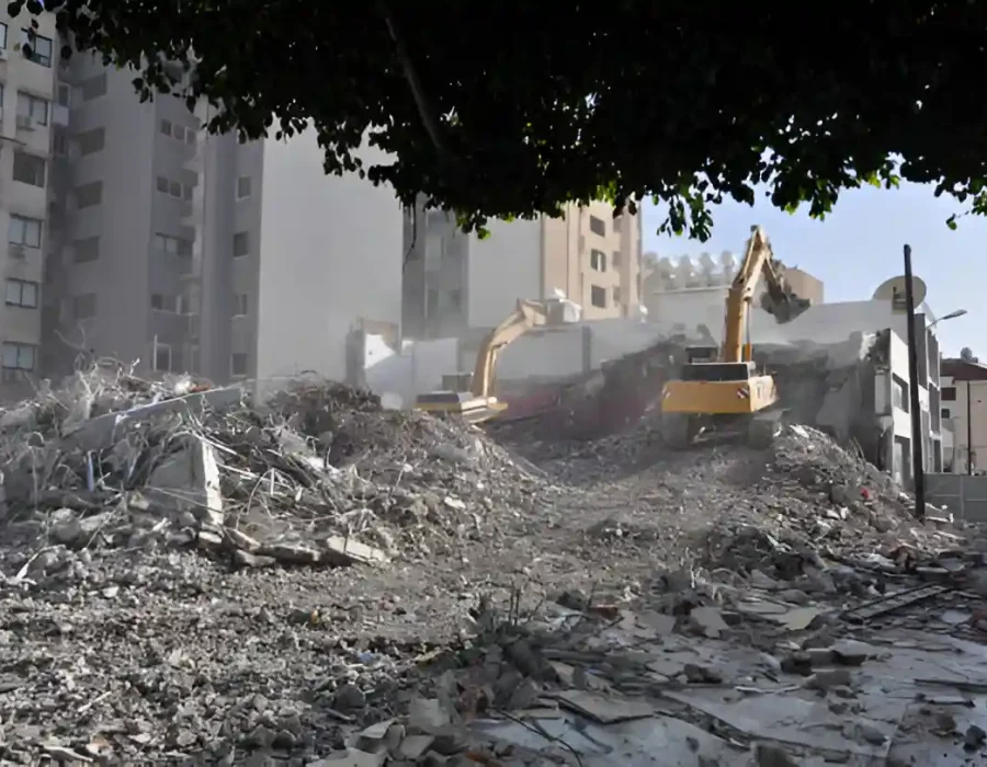 Excavators clearing rubble from demolished building site