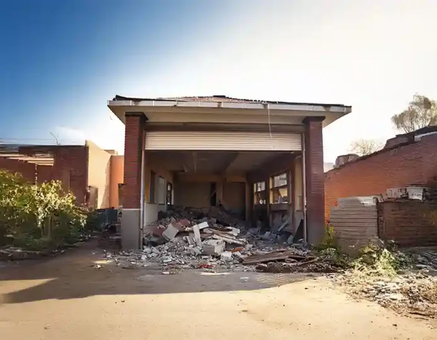 Partially demolished garage showing debris and rubble scattered across the site area.
