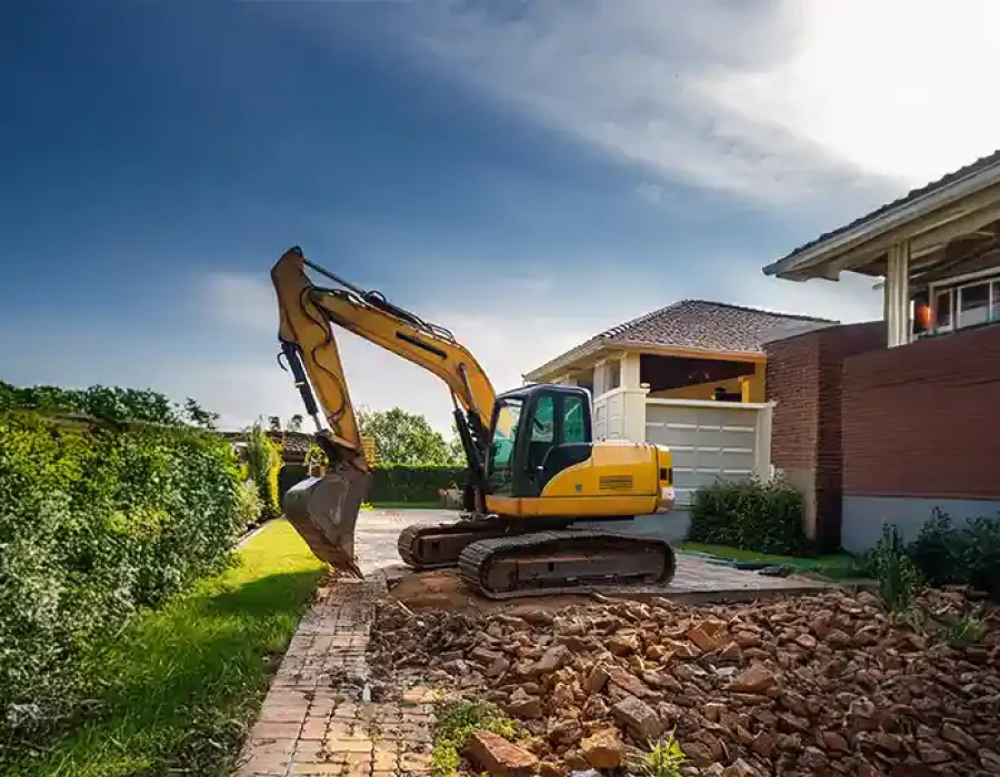 Heavy equipment performing demolition and debris removal at a construction site.