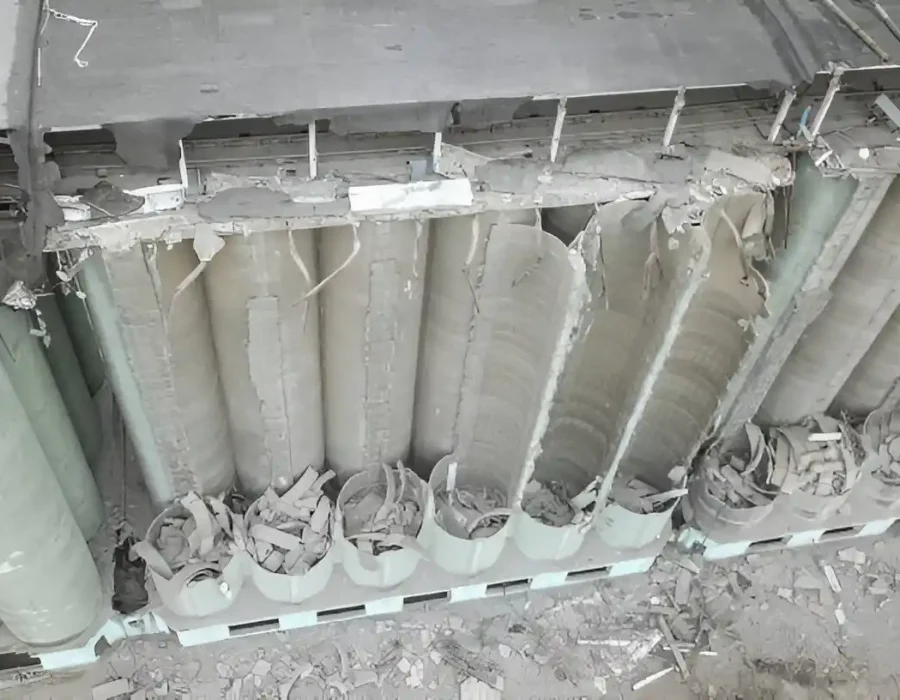Concrete cylinders partially demolished, industrial site debris removal process