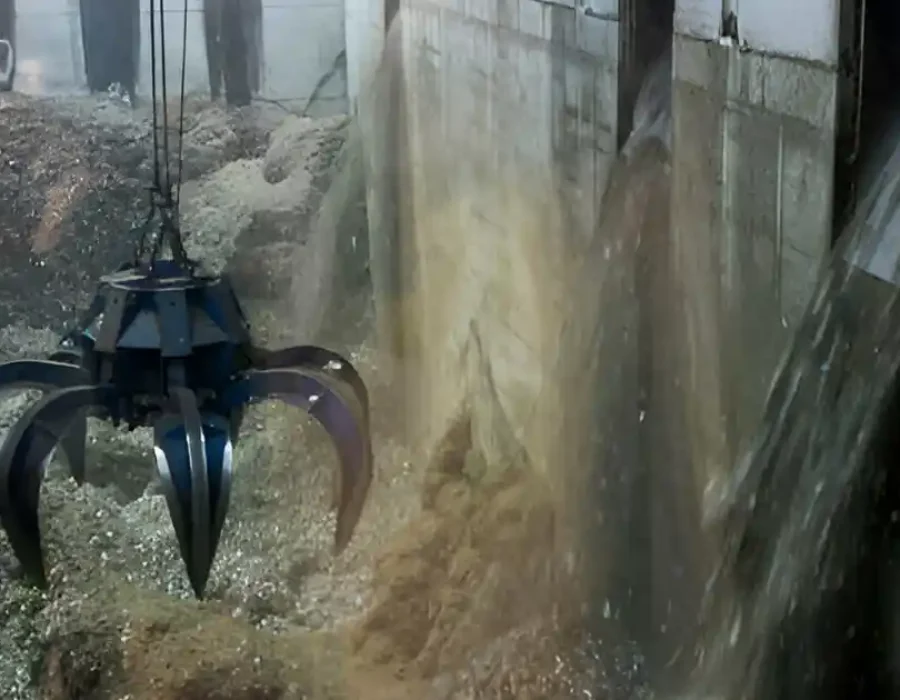 Claw grabber lifting debris during industrial waste removal.