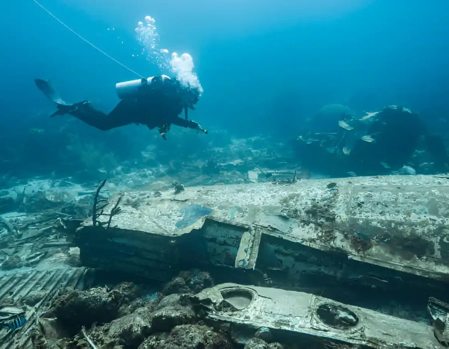 Diver inspects sunken vessel for marine site cleanup operations