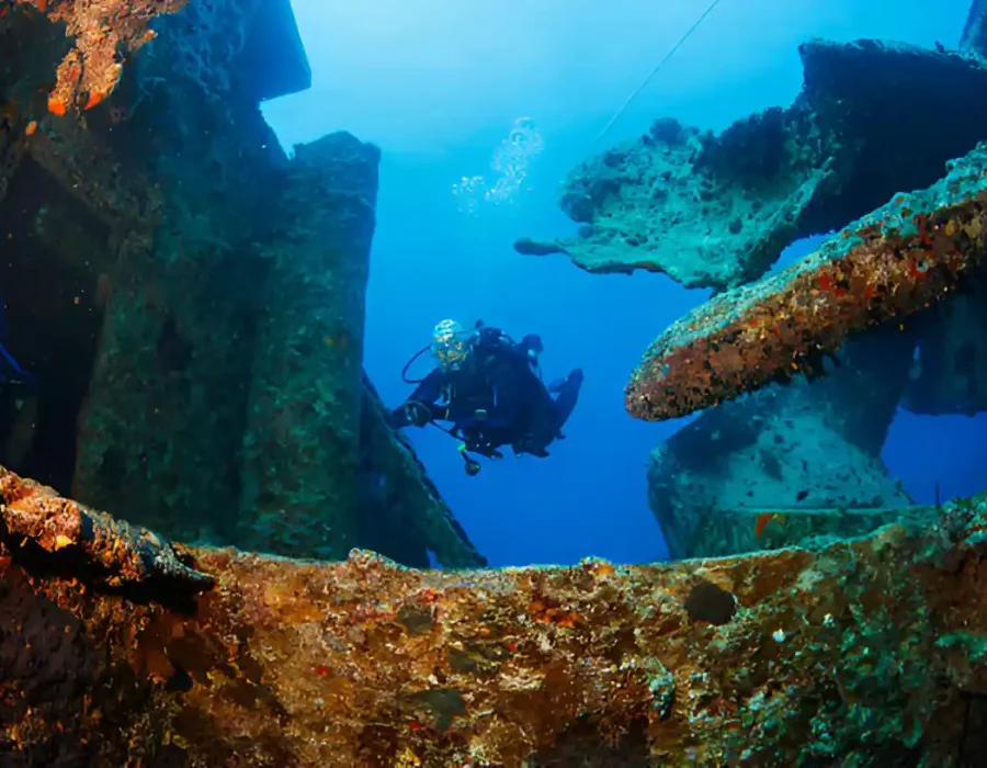 Diver inspects corroded maritime structure for underwater cleanup