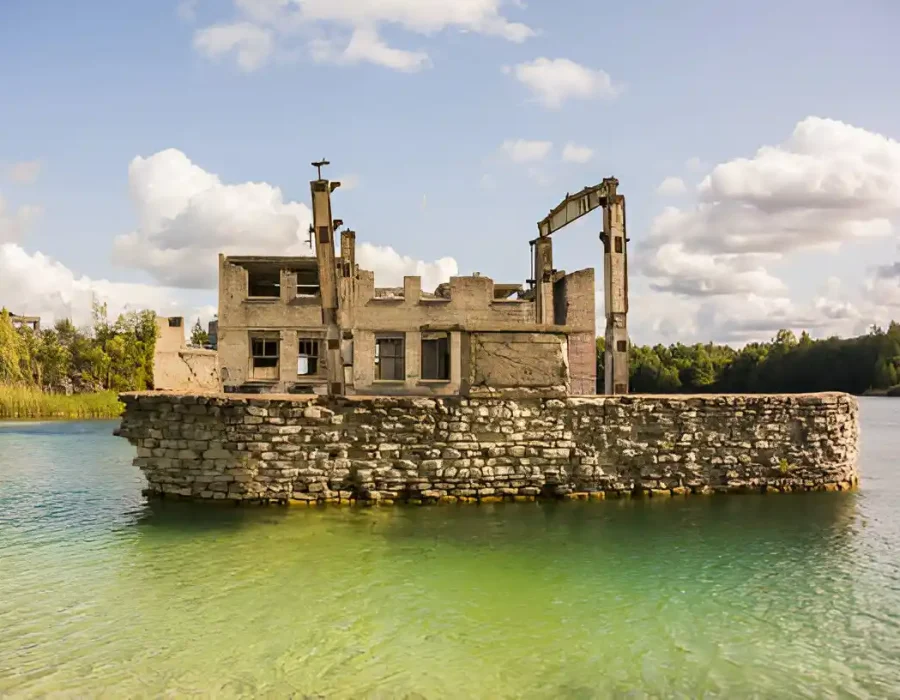 Abandoned stone building prepared for controlled demolition near water
