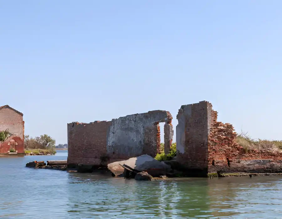 Ruined brick building in water prepared for controlled demolition project